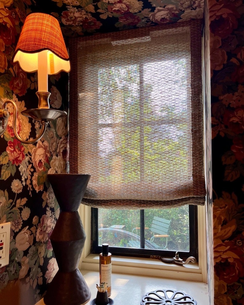 Natural grass sheer shade in room with floral wallpaper
