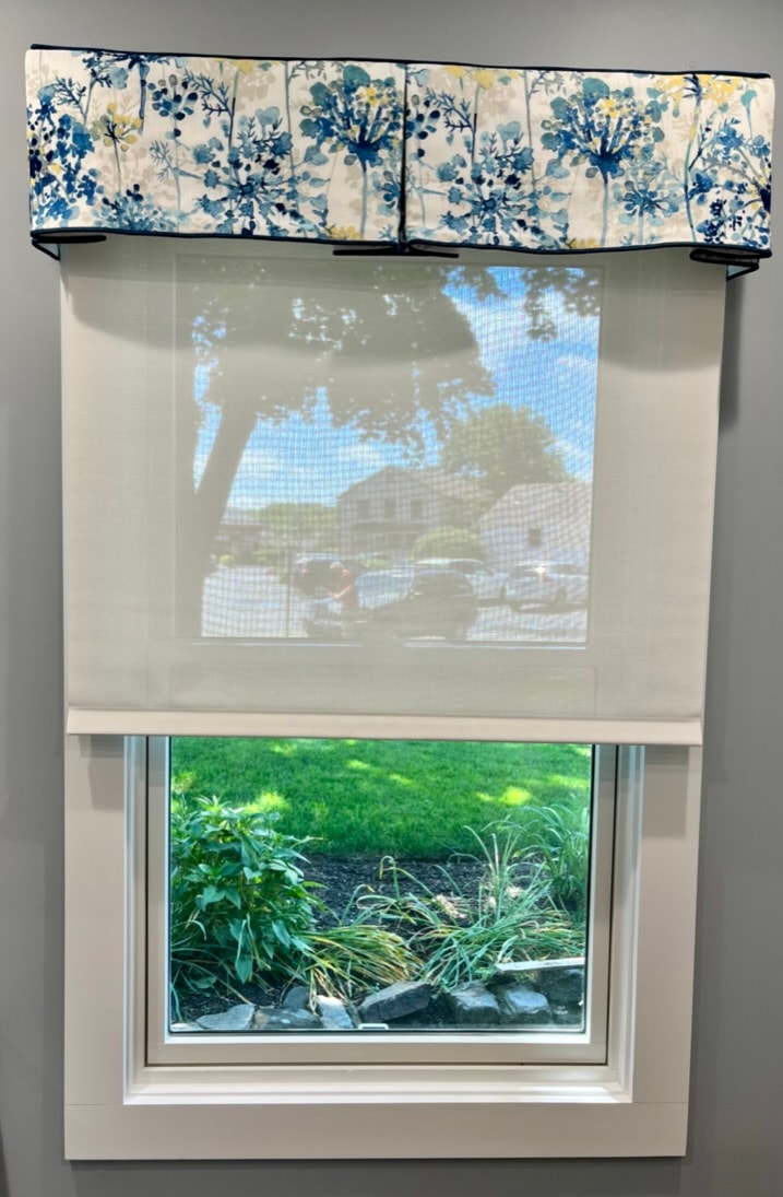 Window with blue floral valance and sheer shade
