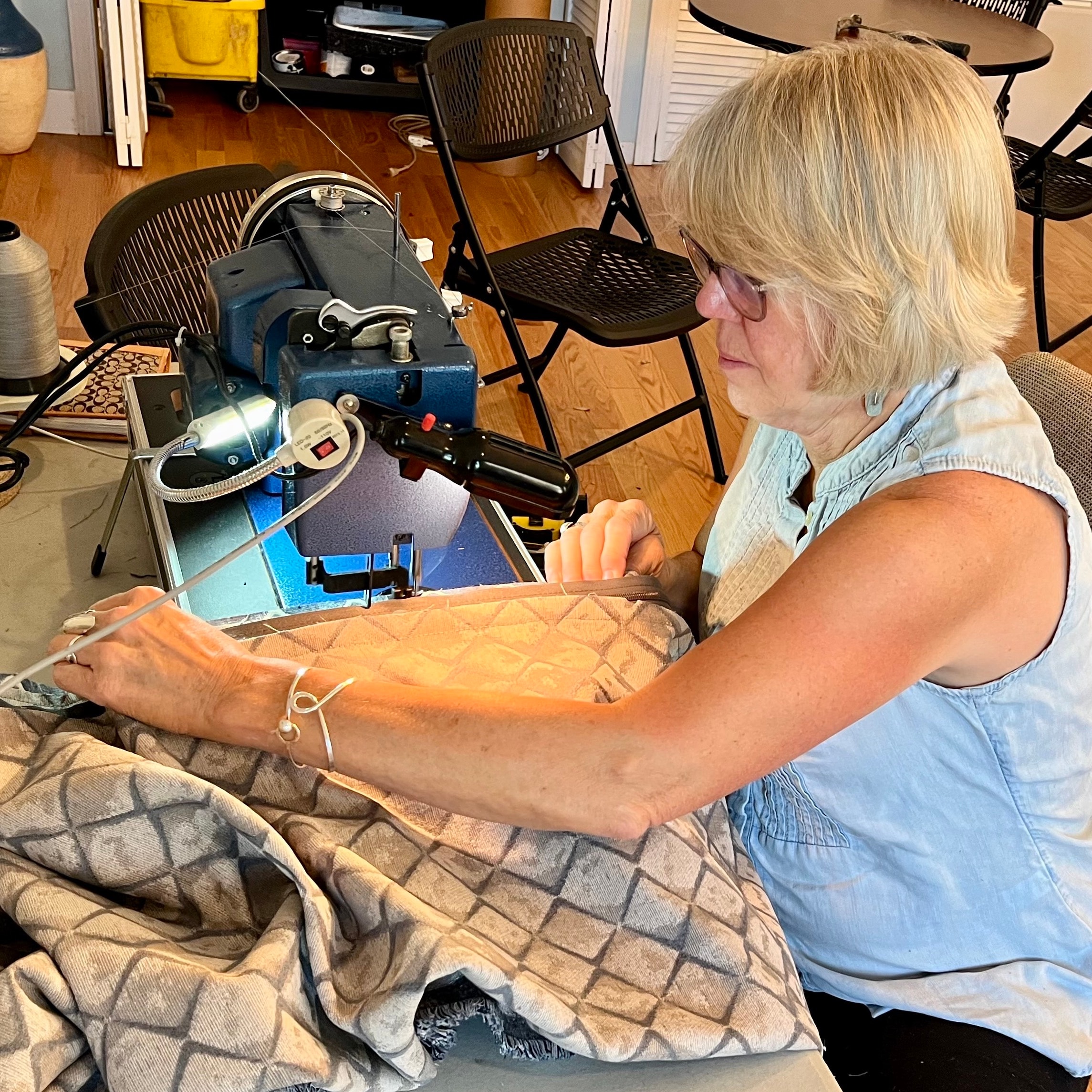 Heather sewing fabric at her workroom machine